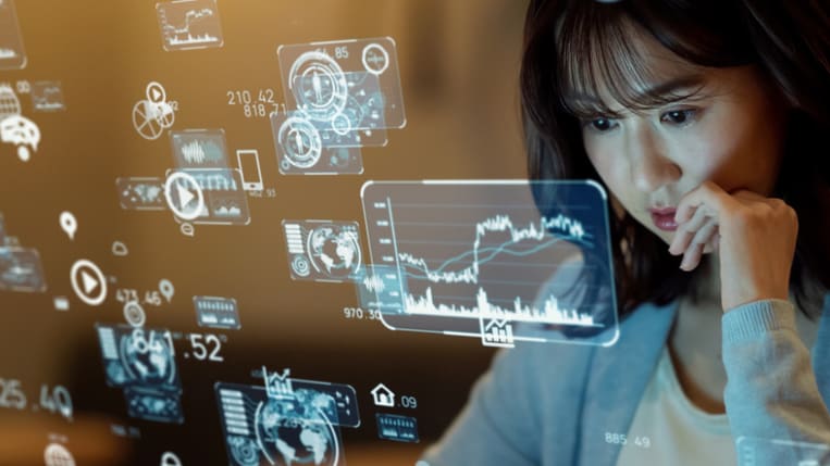 You Asian woman concentrates when looking at a variety of charts and other digital images.