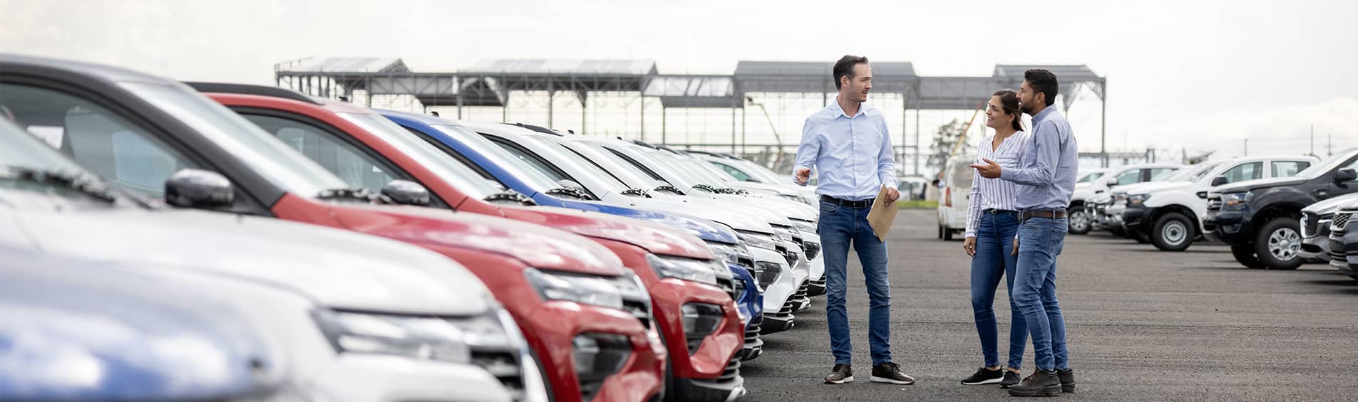 Salesman showing cars to a couple at the dealership